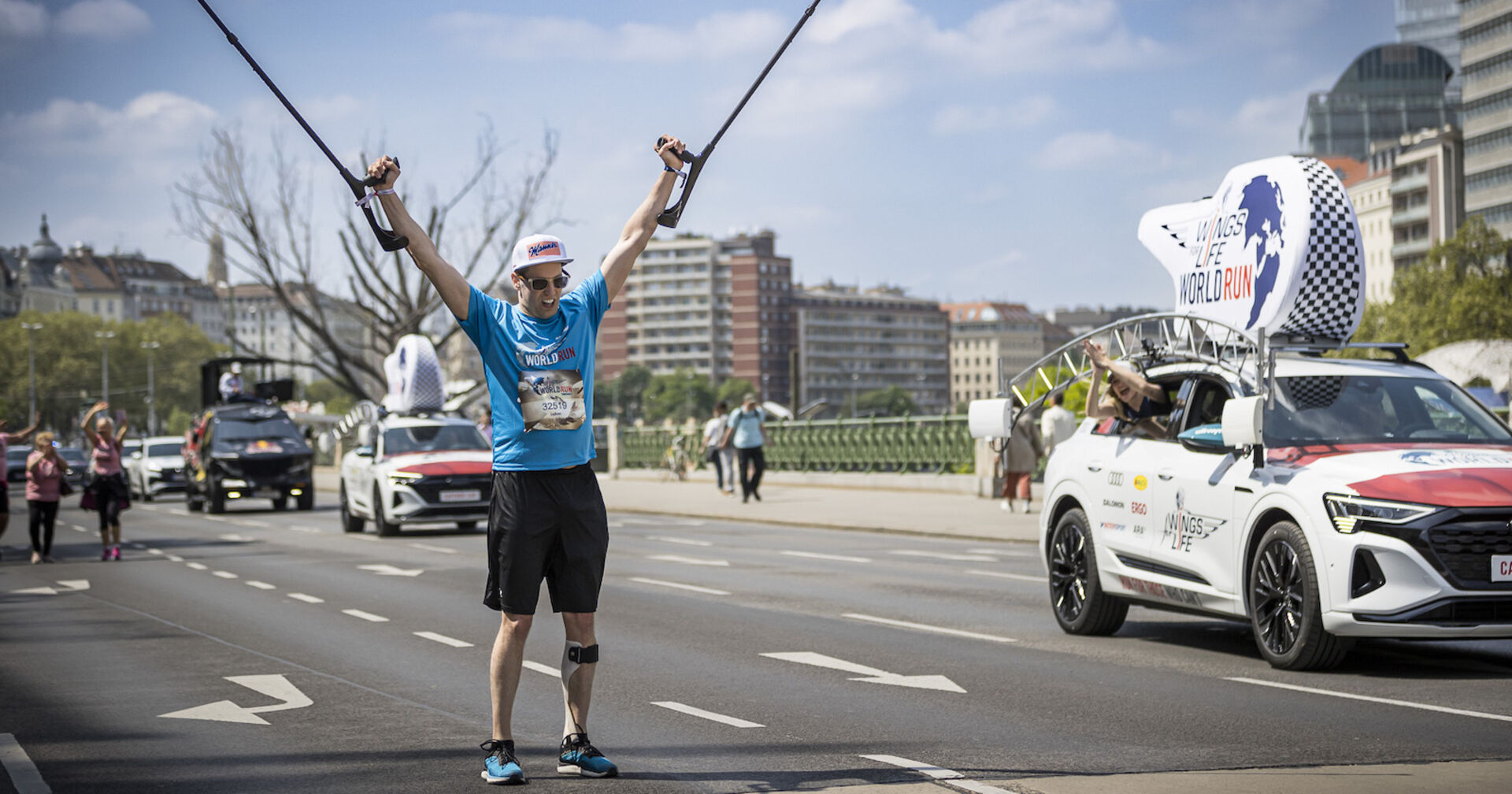 Lukas Müller streckt seine Krücken nach oben und feiert seine Leistung.