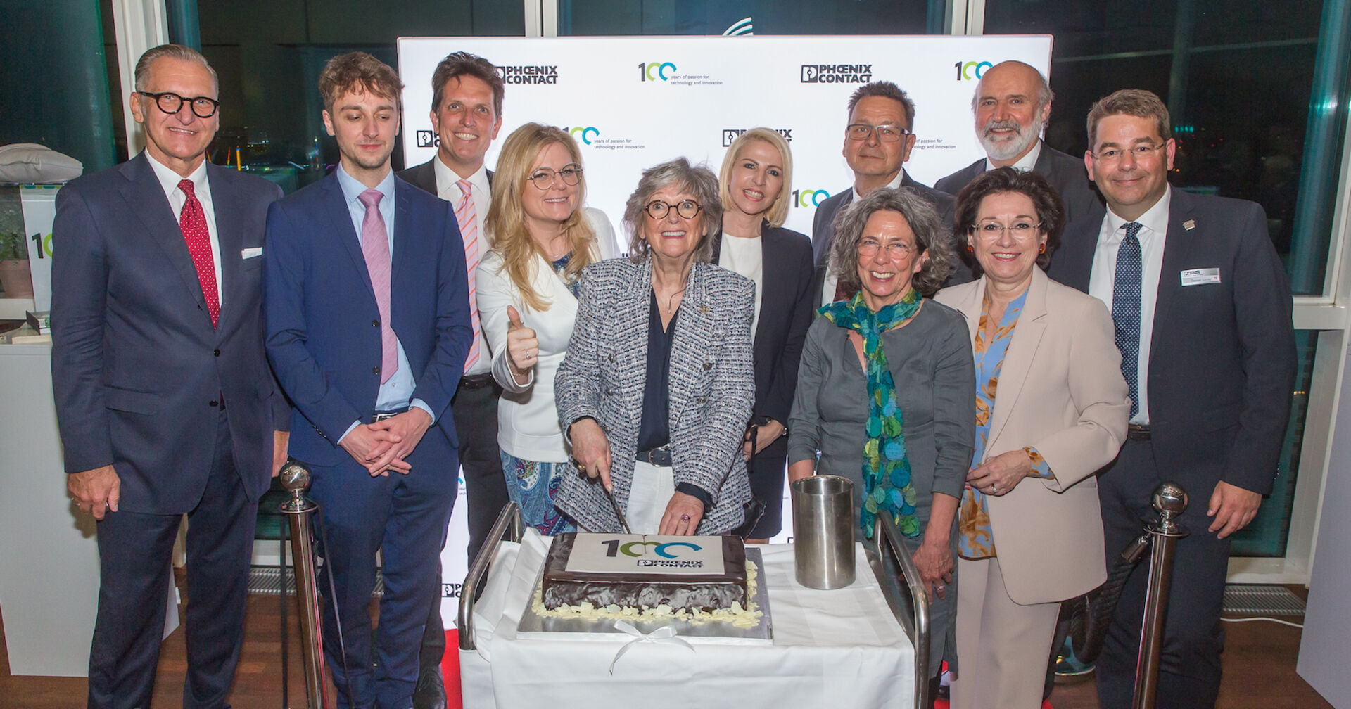 Gäste schneiden gemeinsam die Torte beim Phoenix Contact-Firmengeburtstag an  | Credit: Phoenix Contact