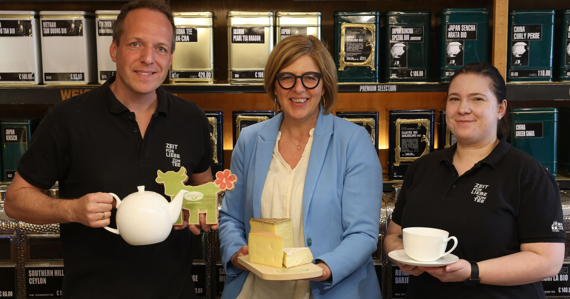 Drei Personen mit Teekannen, Teetassen und Käse im Teegeschäft| Credit: ARGE Heumilch