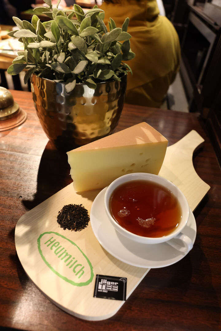 Heumilch-Käse und eine Tasse Tee auf einem Holzbrett | Credit: ARGE Heumilch