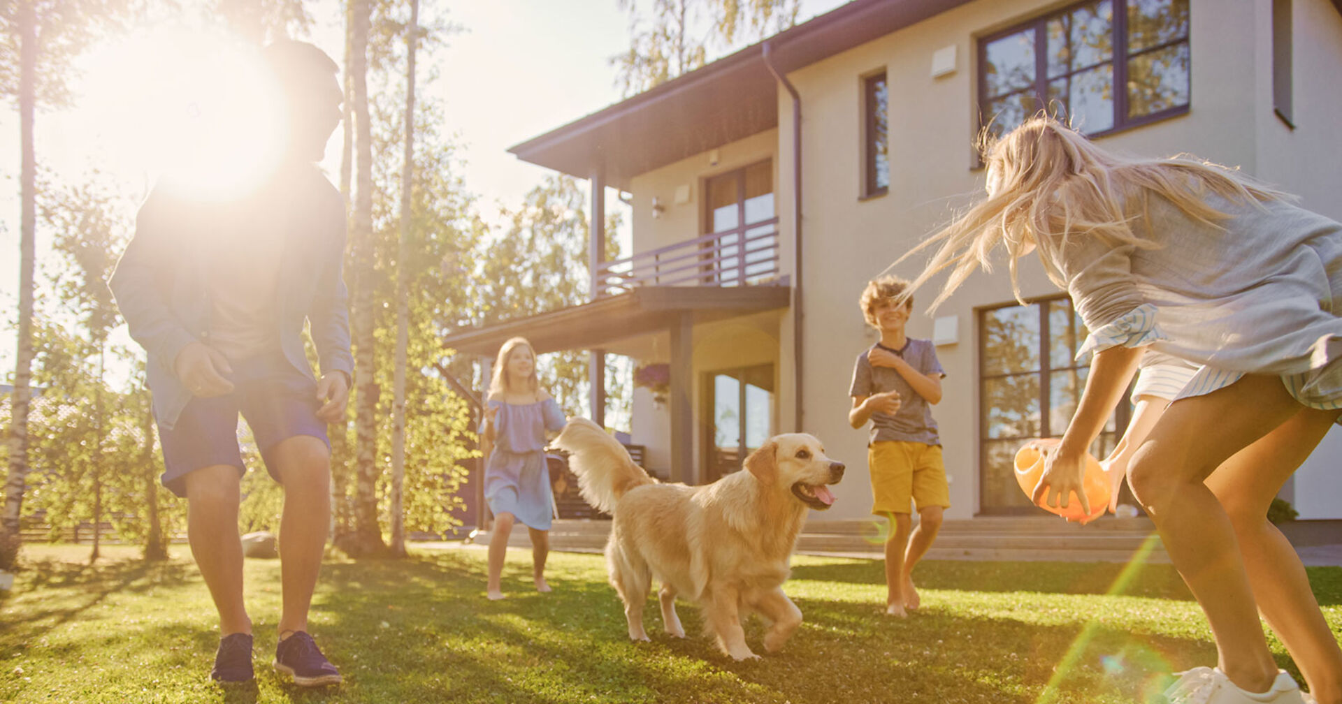 Elternpaar spielt mit seinen Kindern und seinem Golden Retriever im Garten | Credit: iStock.com/gorodenkoff