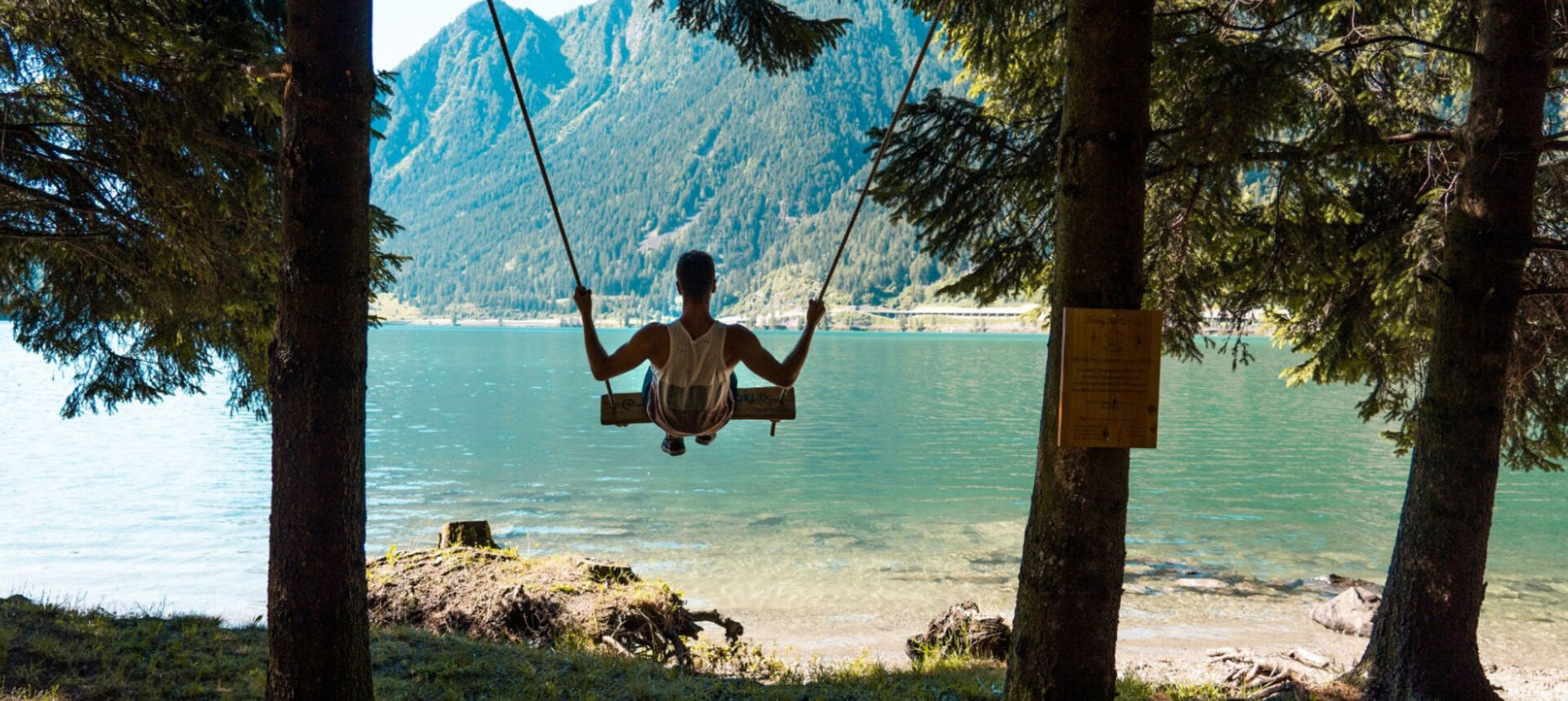 Junger Mann schaukelt man Ufer des Lago di Poschiavo | Credit: Valposchiavo Turismo