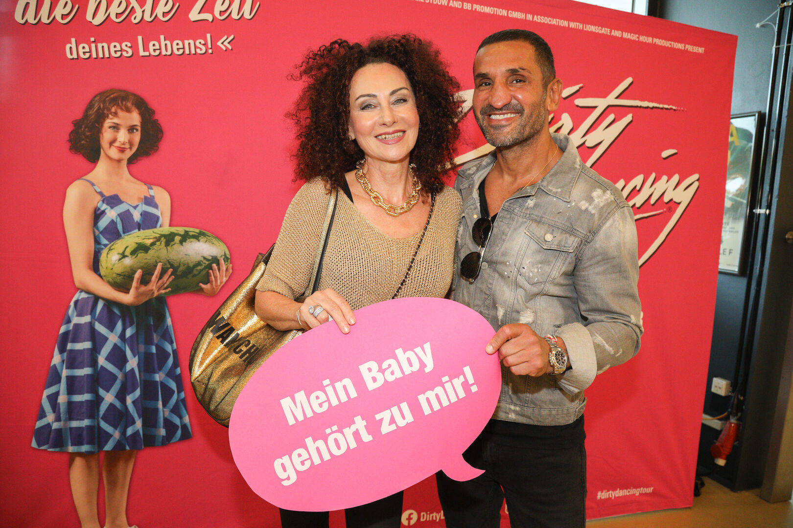Mausi Lugner und Fadi Merza halten ein Plakat in der Hand.