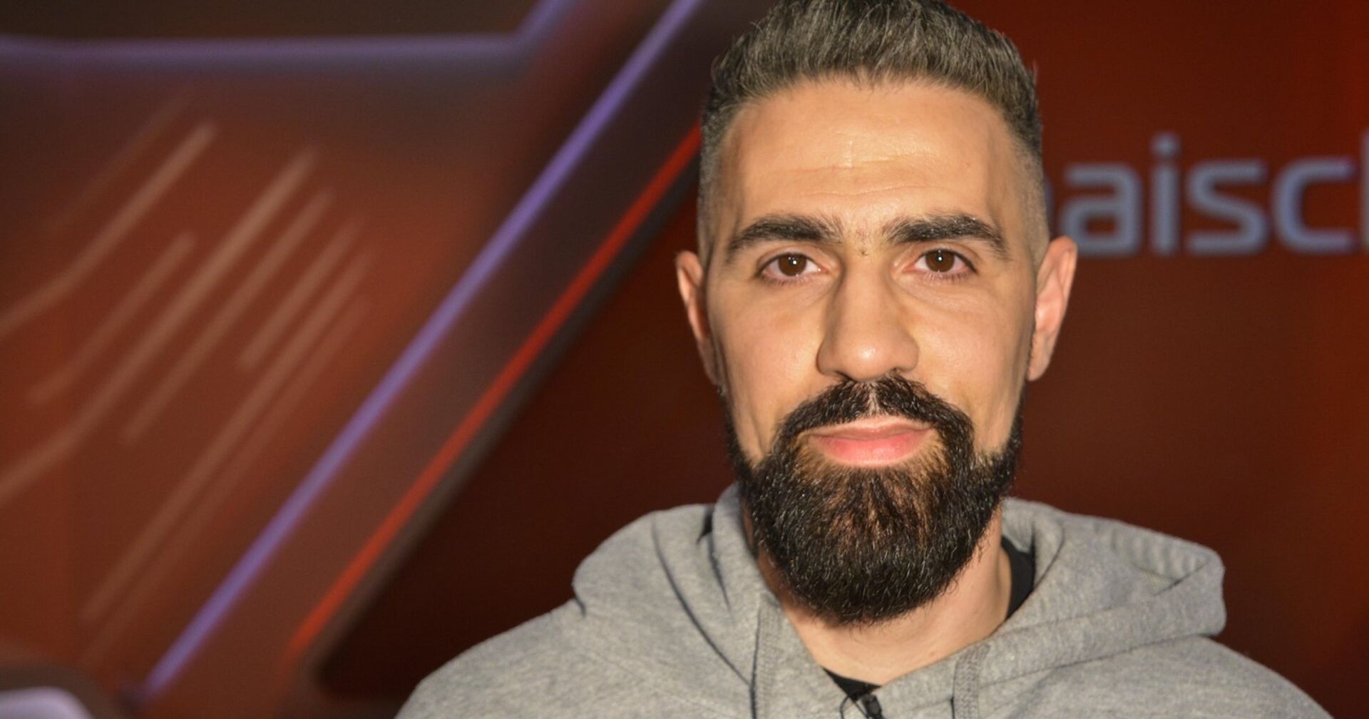 Ein Mann mit Bart schaut in die Kamera.