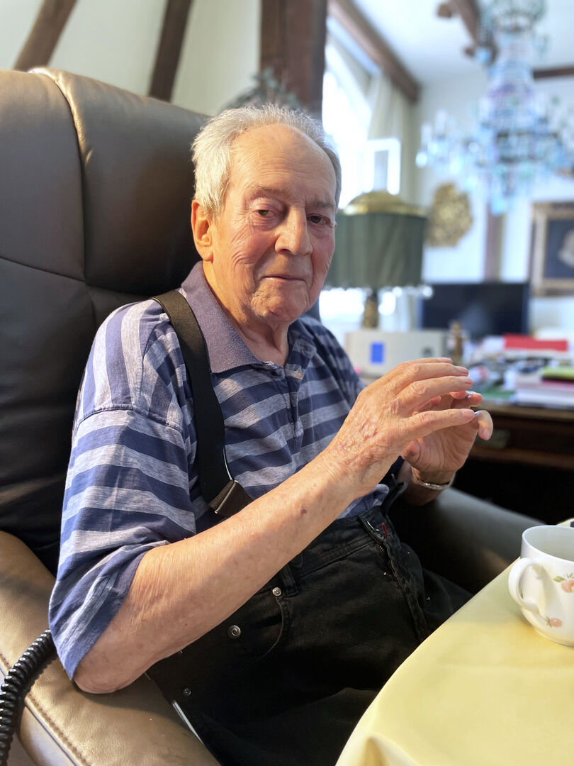 Otto Schenk sitzt in einem Lehnstuhl vor einer Tasse.
