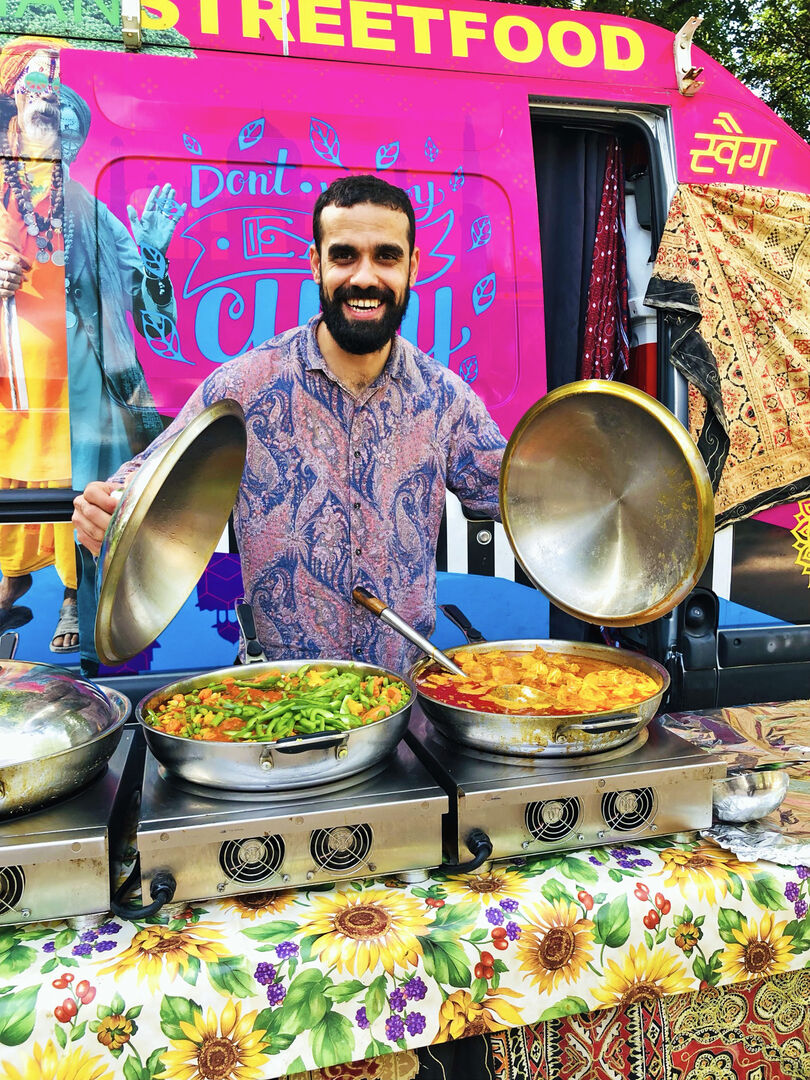 Mann kocht in Pfannen für den Street Food Market