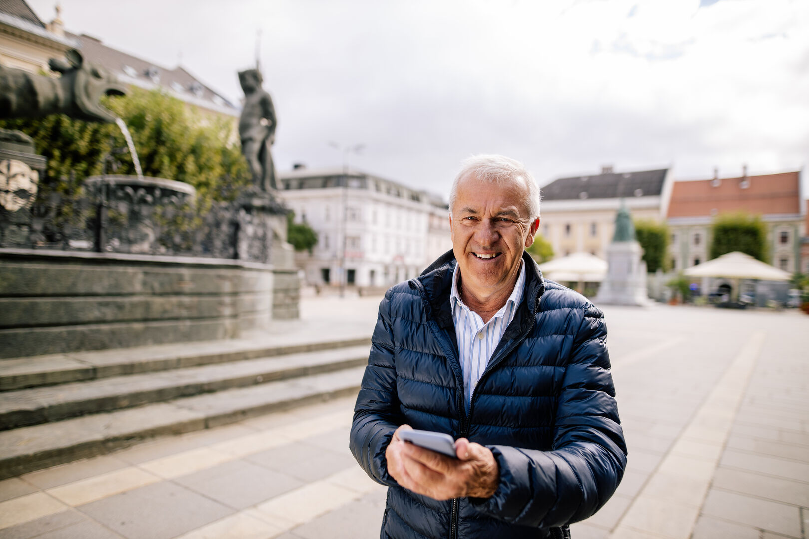 Mann probiert App am Handy vor Lindwurm Klagenfurt aus