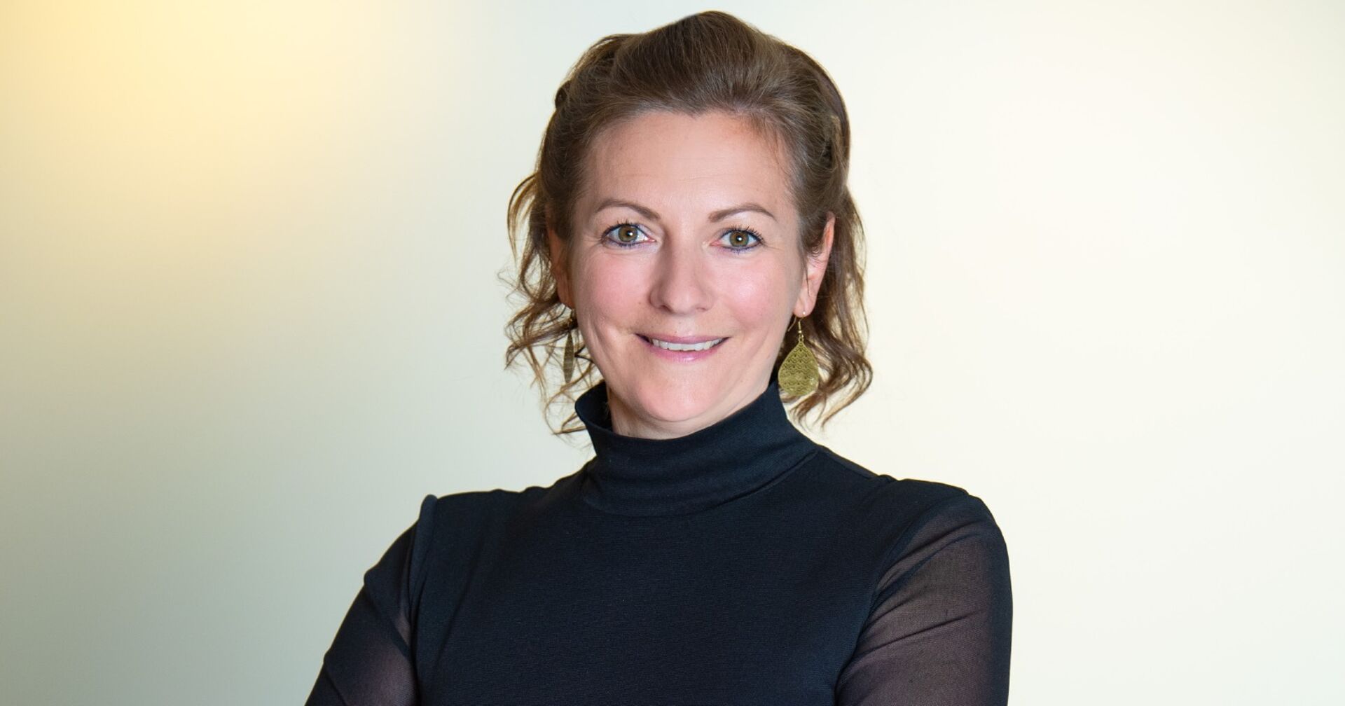 Porträt von Karina Winkler, die ein schwarzes Business-Outfit trägt