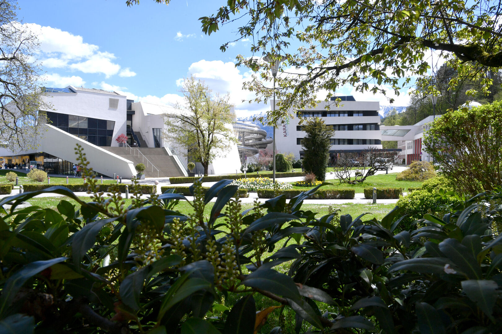 Aufnahme des Thermenhotels Karawankenhof - zahlreiche grüne Streucher und Äste rahmen das Motiv