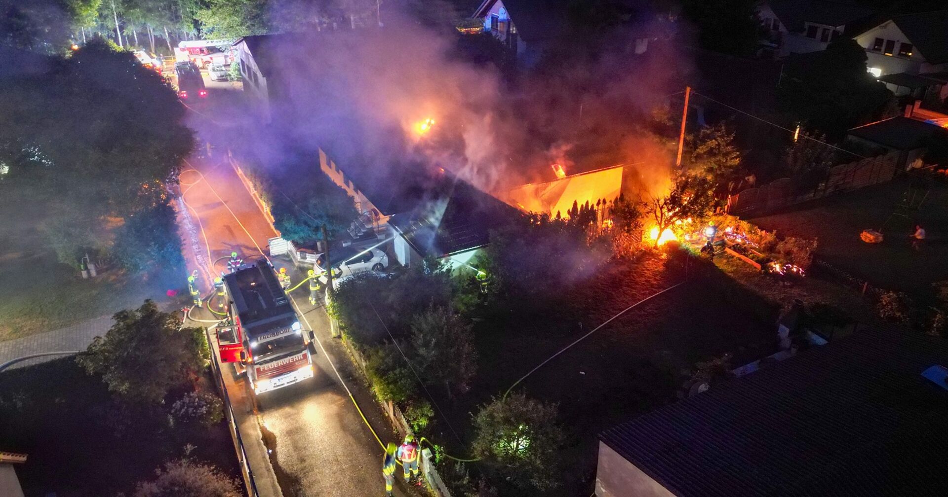 Ein Wohnhaus steht in Flammen, die Feuerwehr ist im Einsatz