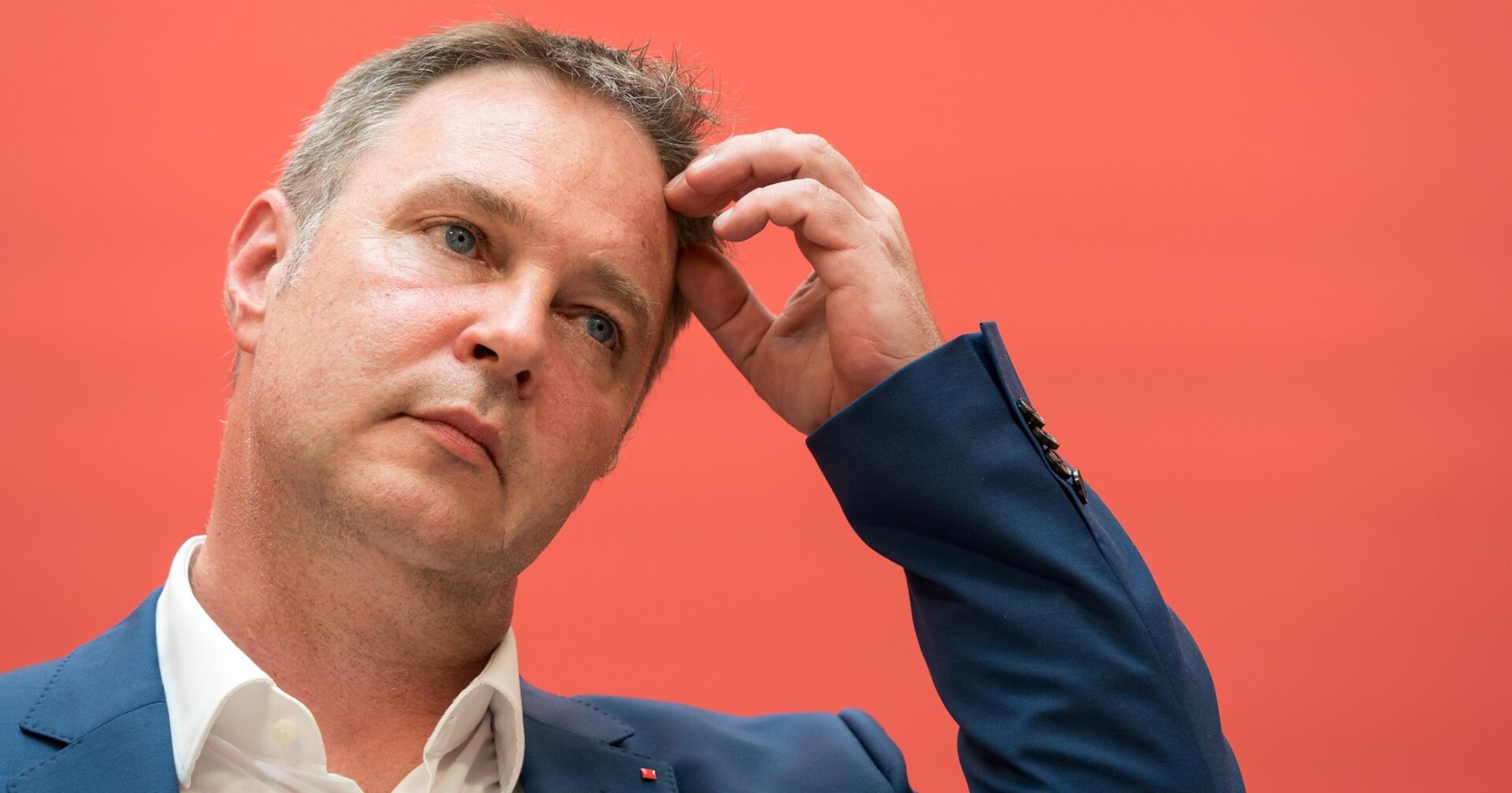 Andreas Babler bei einer Pressekonferenz vor der Pressewand der SPÖ. Er greift sich an den Kopf