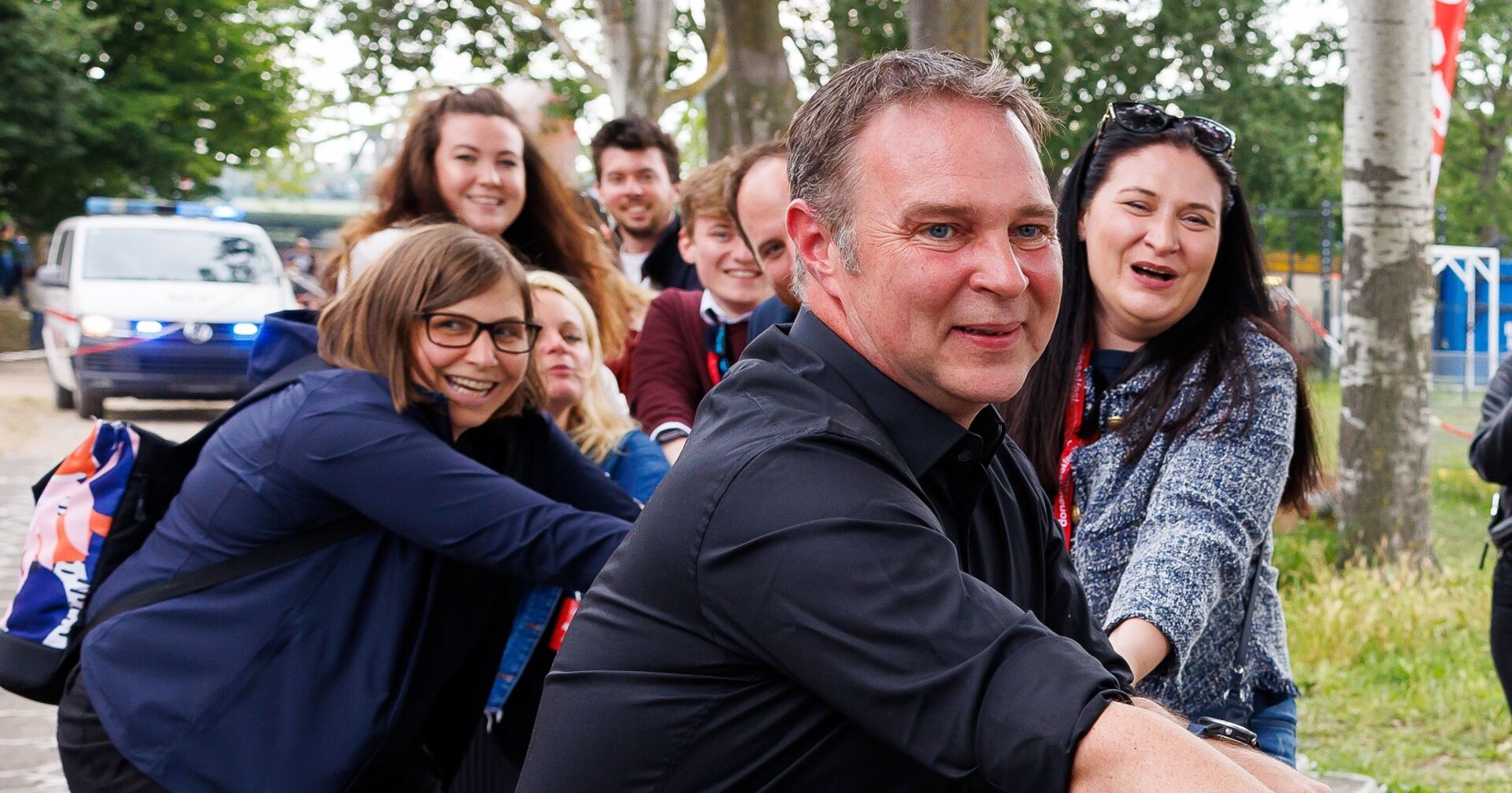 Andreas Babler, hinter ihm einige Menschen. Nicht klar erkennbar: Sie ziehen gemeinsam an einem Seil
