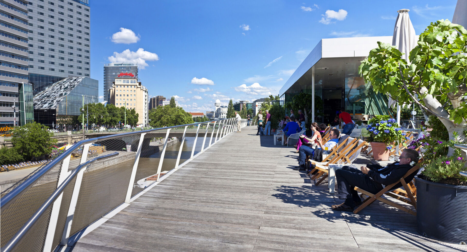 Menschen sitzen zusammen am Donaukanal in Wien | Credit: iStock.com/Creativemarc