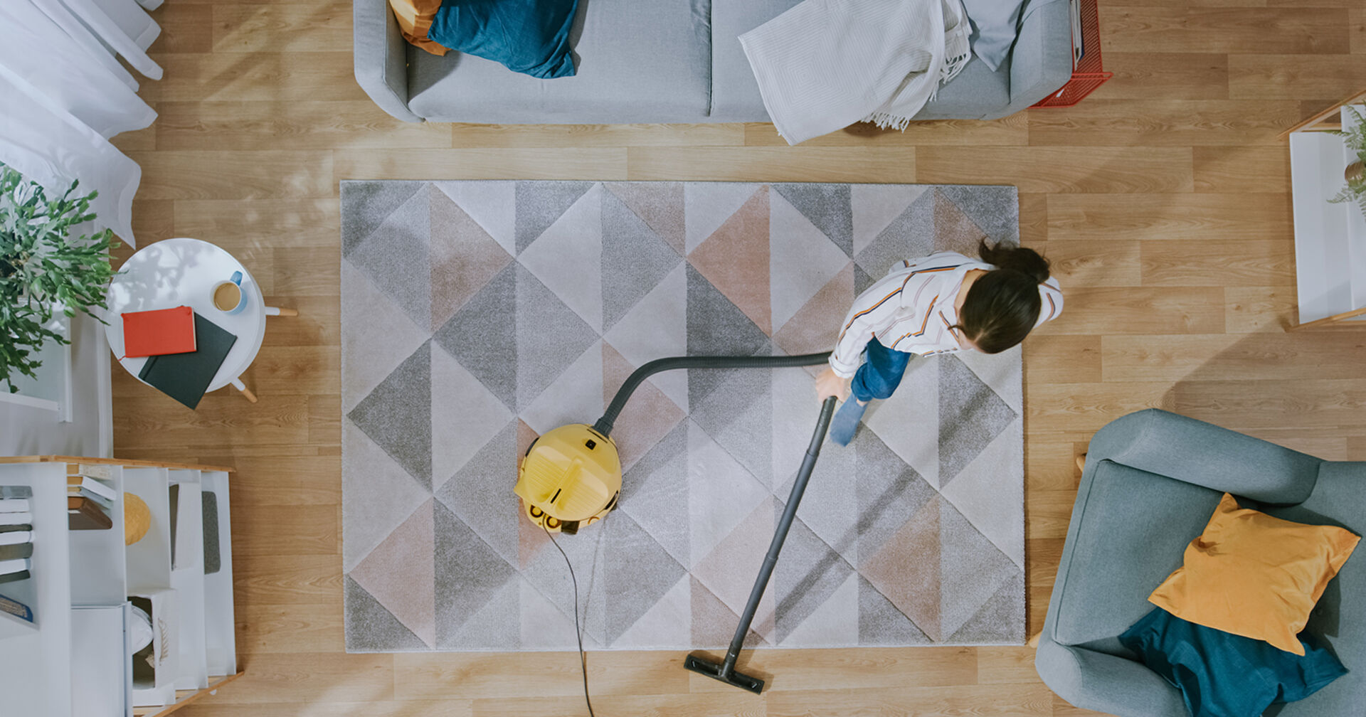 Frau saugt das Wohnzimmer | Credit: iStock.com/gorodenkoff