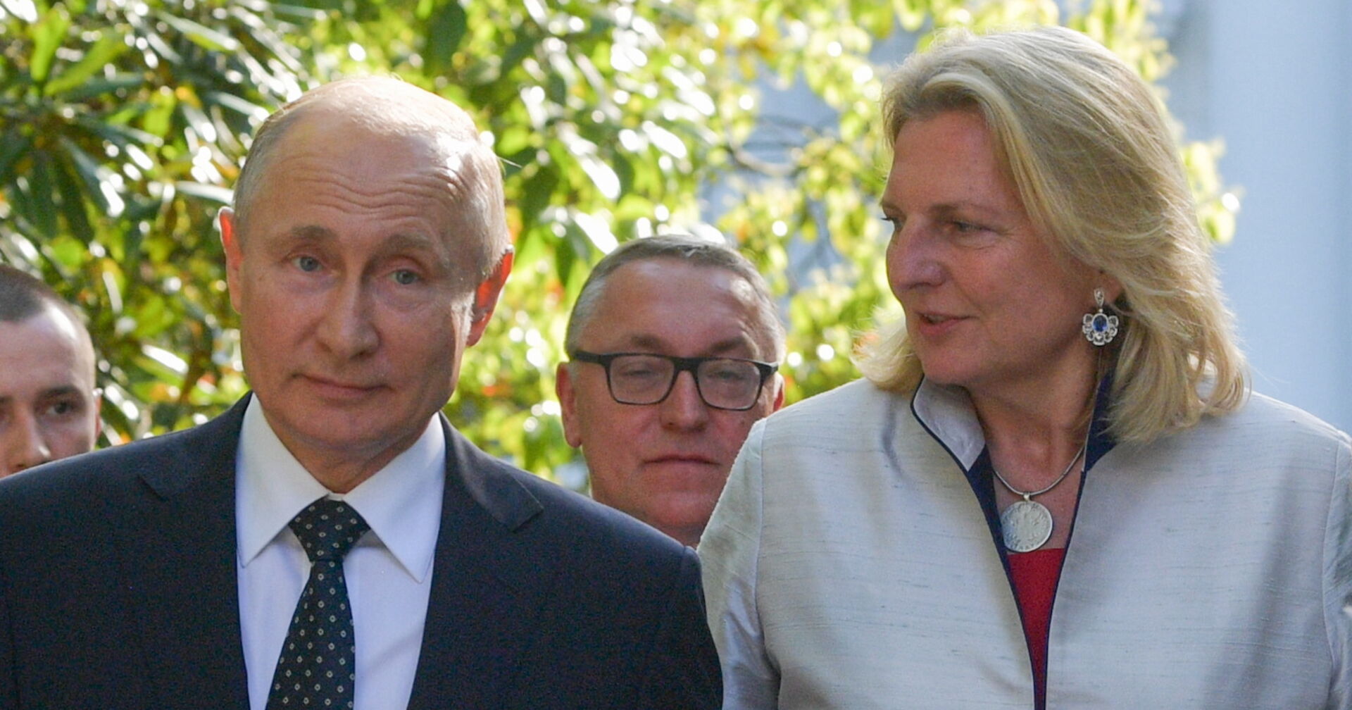 Putin und Kneissl gehen Schulter an Schulter. Sie schaut ihn von der Seite an und sagt etwas