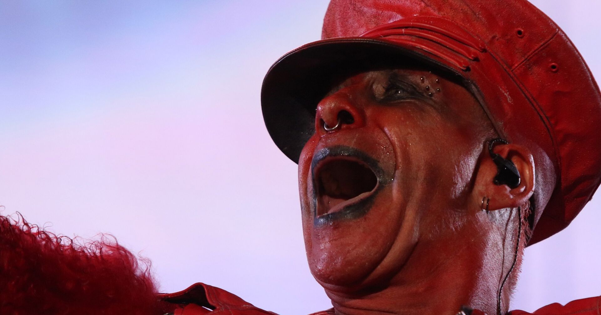 Rammstein-Frontsänger Till Lindemann rot angemalt in rotem Kostüm, live in Action auf der Bühne