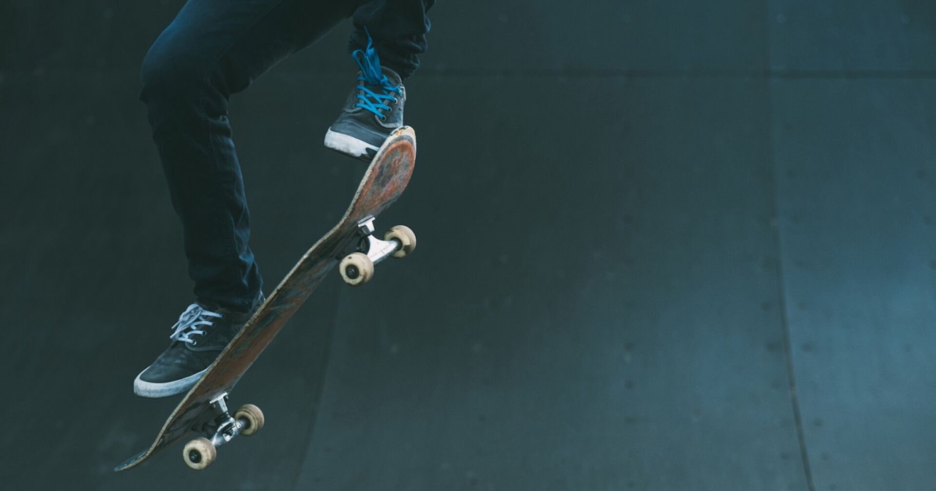 Zwei Füße und ein Skateboard in der Luft.