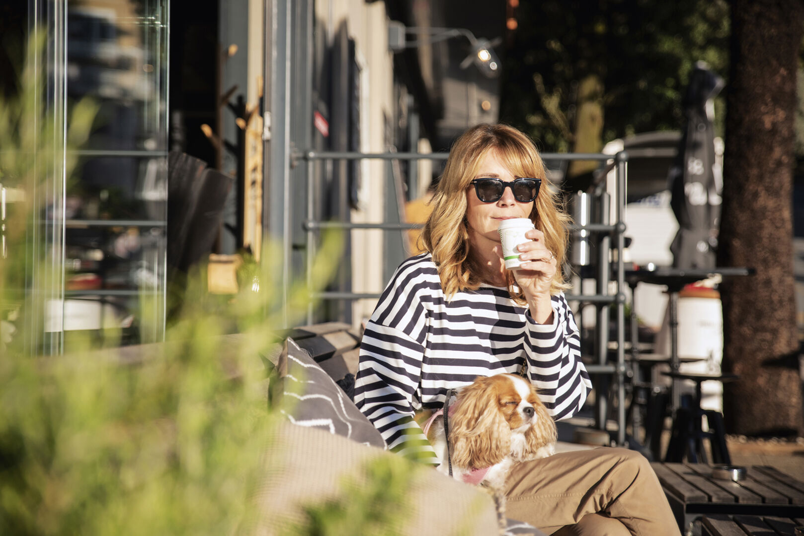 Frau sitzt mit Hund in der Stadt | Credit: iStock.com/Szepy