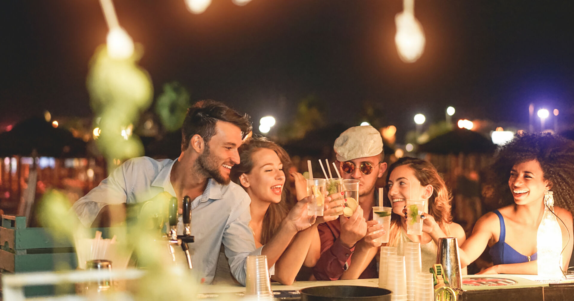Freunde sitzen an der Bar | Credit: iStock.com/DisobeyArt