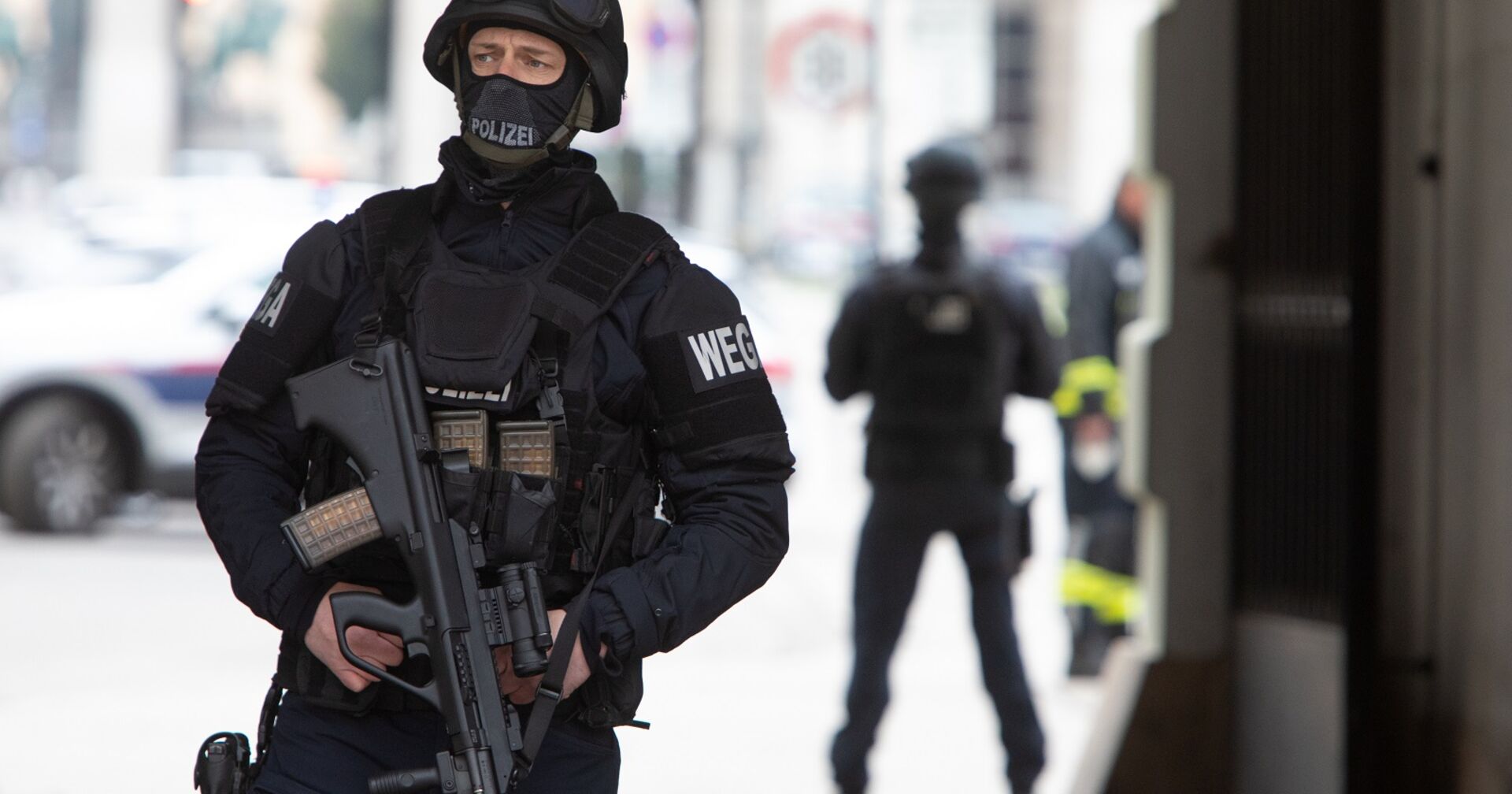 Ein schwerbewaffneter Polizist mit Schutzkleidung. Am Arm die Aufschrift Wega.