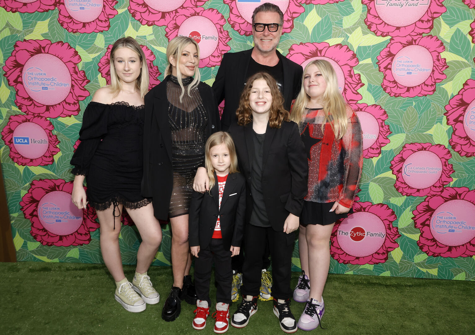 Eine Ehepaar mit fünf Kindern vor einer bunten Wand.