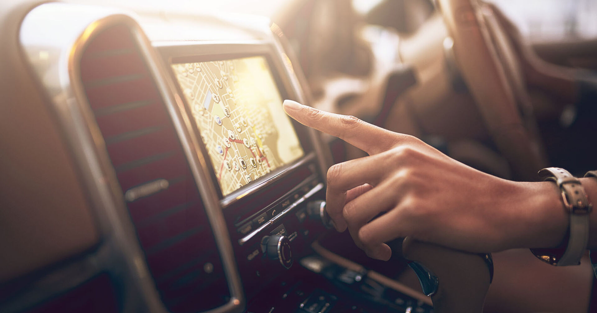 Person bedient das Navigationssystem eines Autos