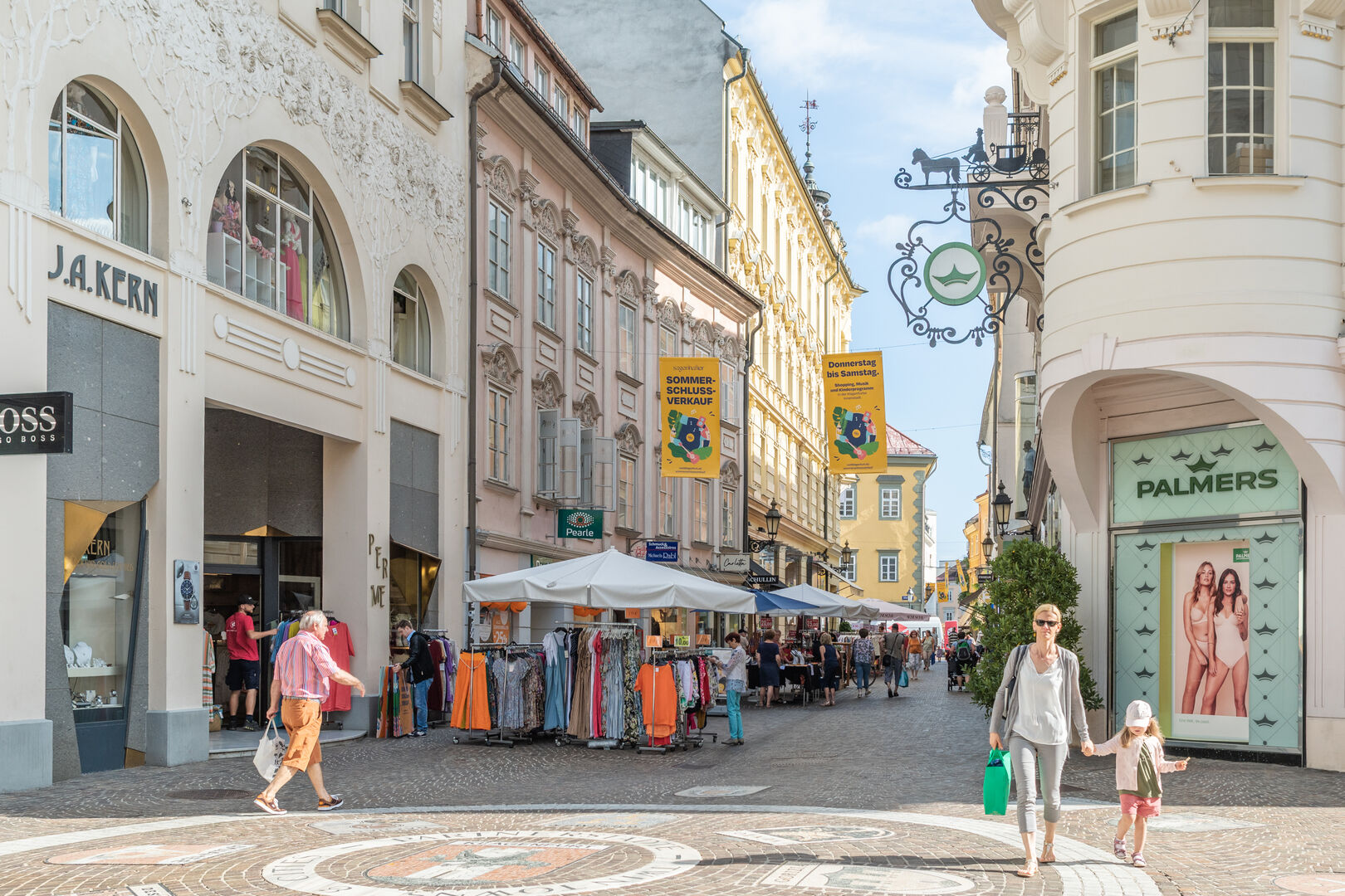 Menschen am Alten Platz Klagenfurt bei Sonnenschein