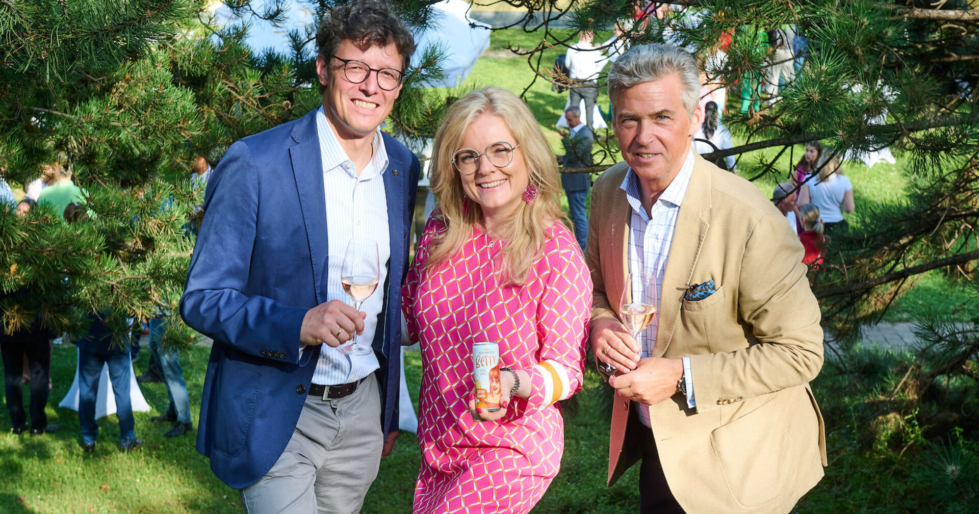 Zwei Männer und eine Frau lächeln beim Sommerfest im Garten der Sektkellerei Schlumberger| Credit:  Sabine Klimpt