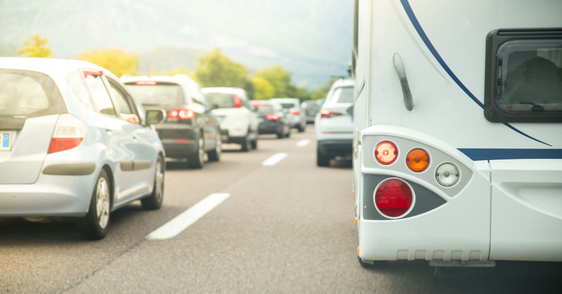 Autos und Wohnmobile stauen auf einer Autobahn.