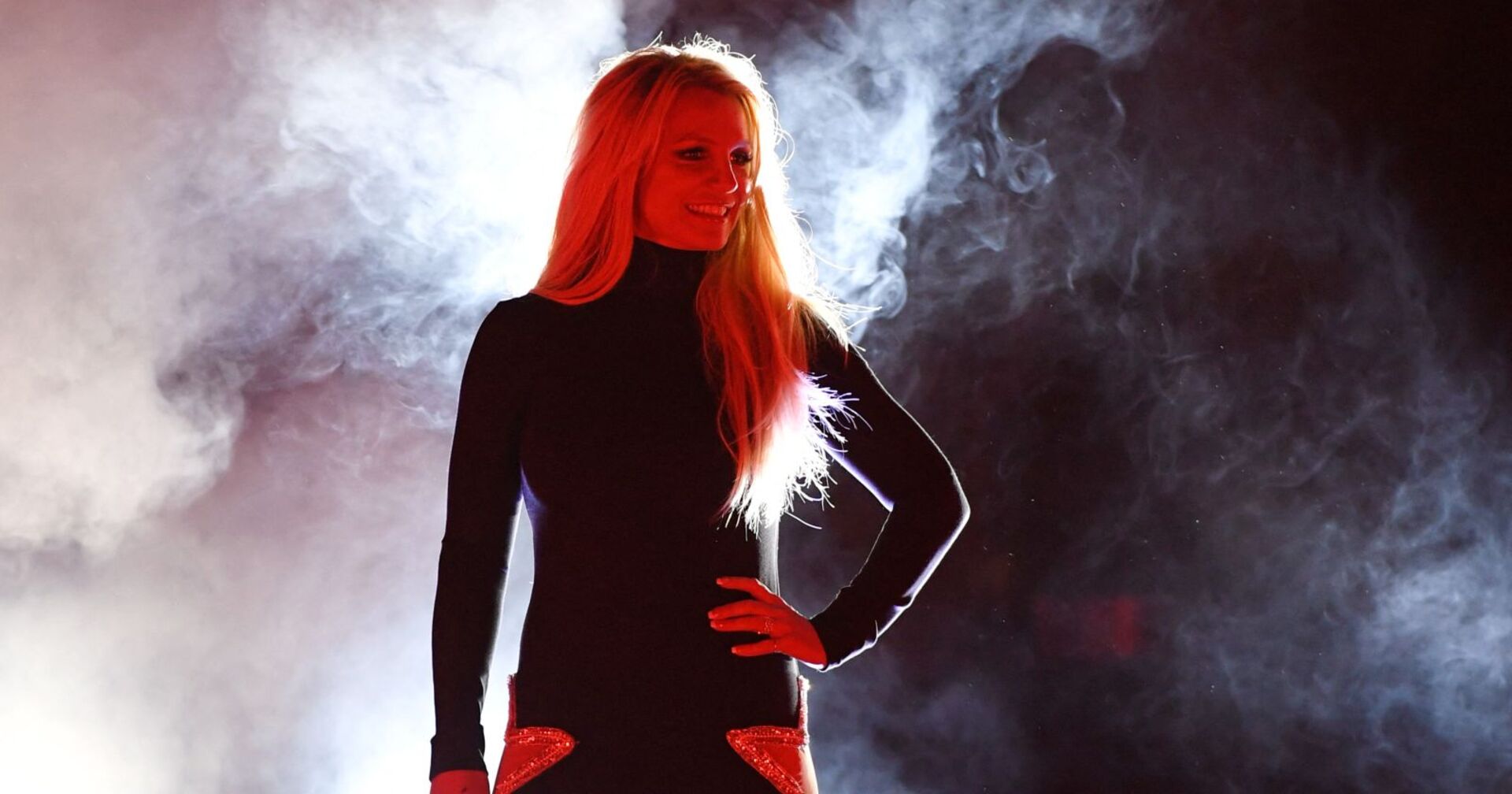 Britney Spears in einem schwarzen Kleid auf der Bühne.