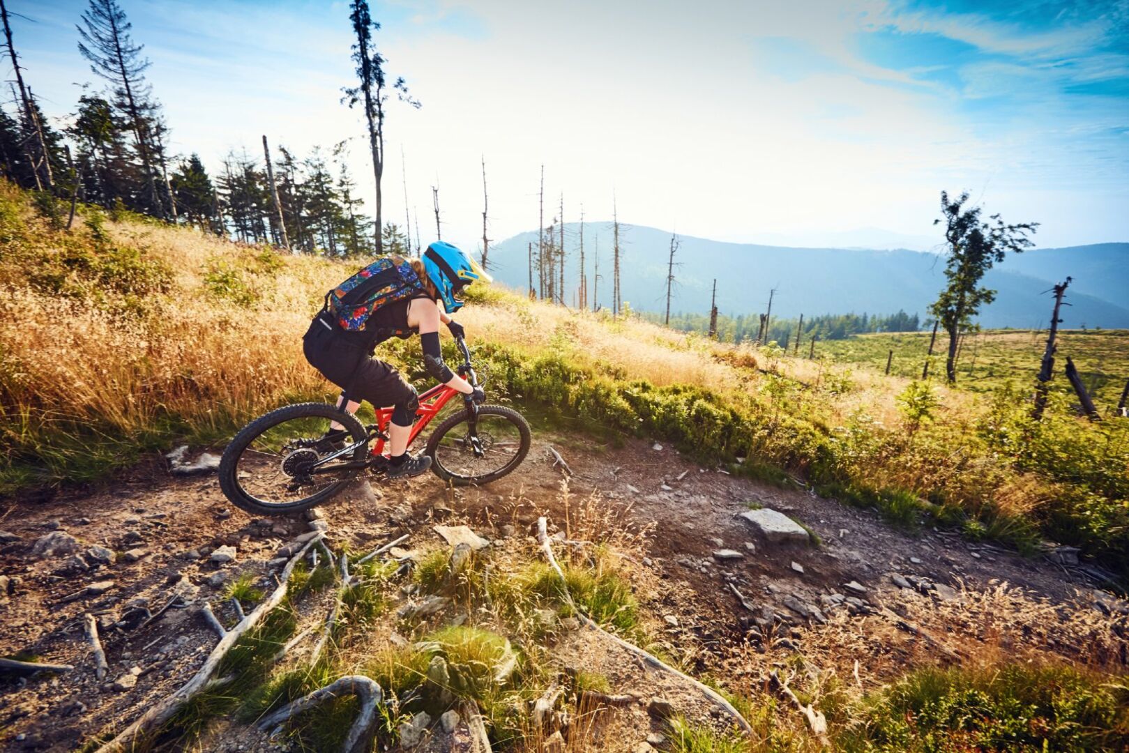 Frau fährt mit Bike bergab | Credit: iStock.com/BartekSzewczyk