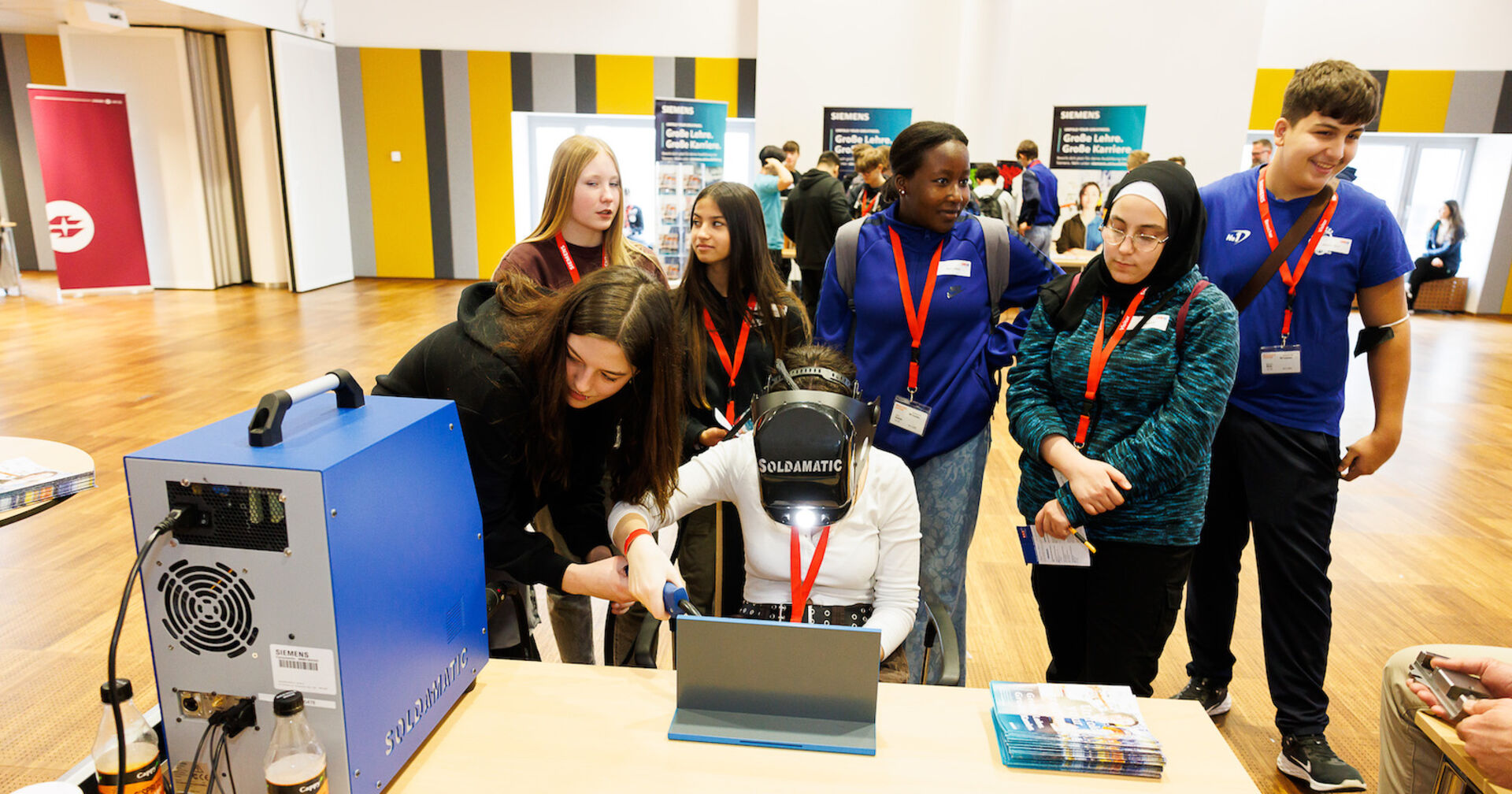 Gruppenbild rund um Geräte auf einen Werkstatttisch