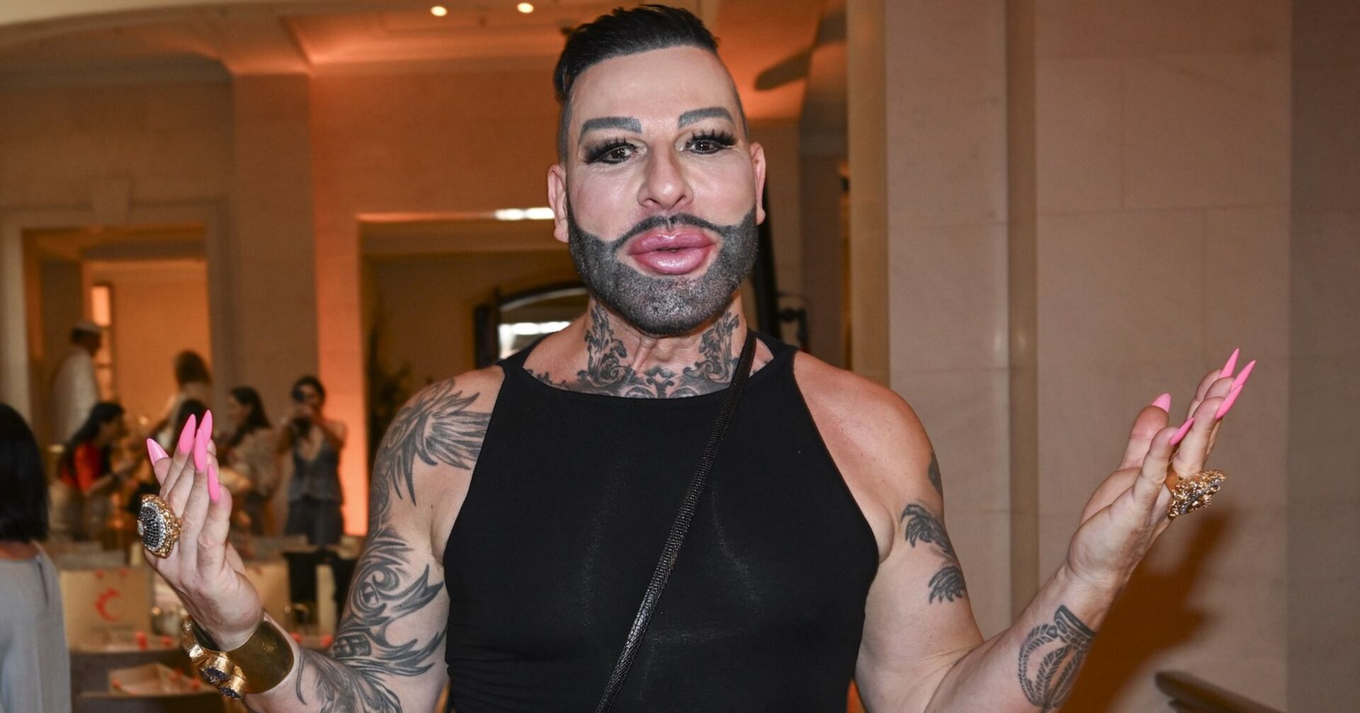 Harald Glööckler in Trägershirt und mit pinken Fingernägeln.