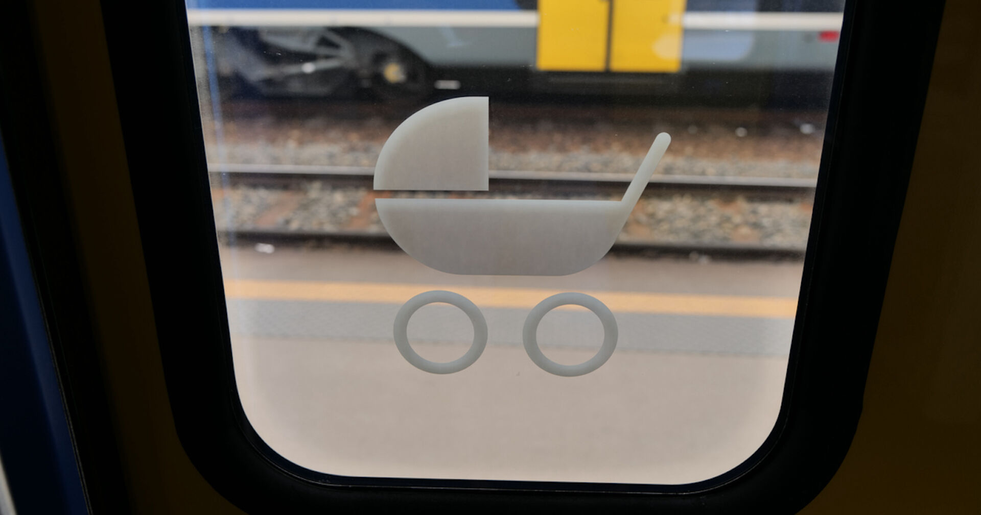 Ein Schild mit einem Kinderwagen auf einer Tür in einem Zug.
