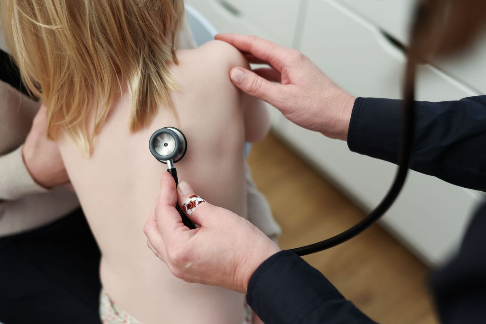 Ein Arzt horcht die Brust eines Kindes ab.