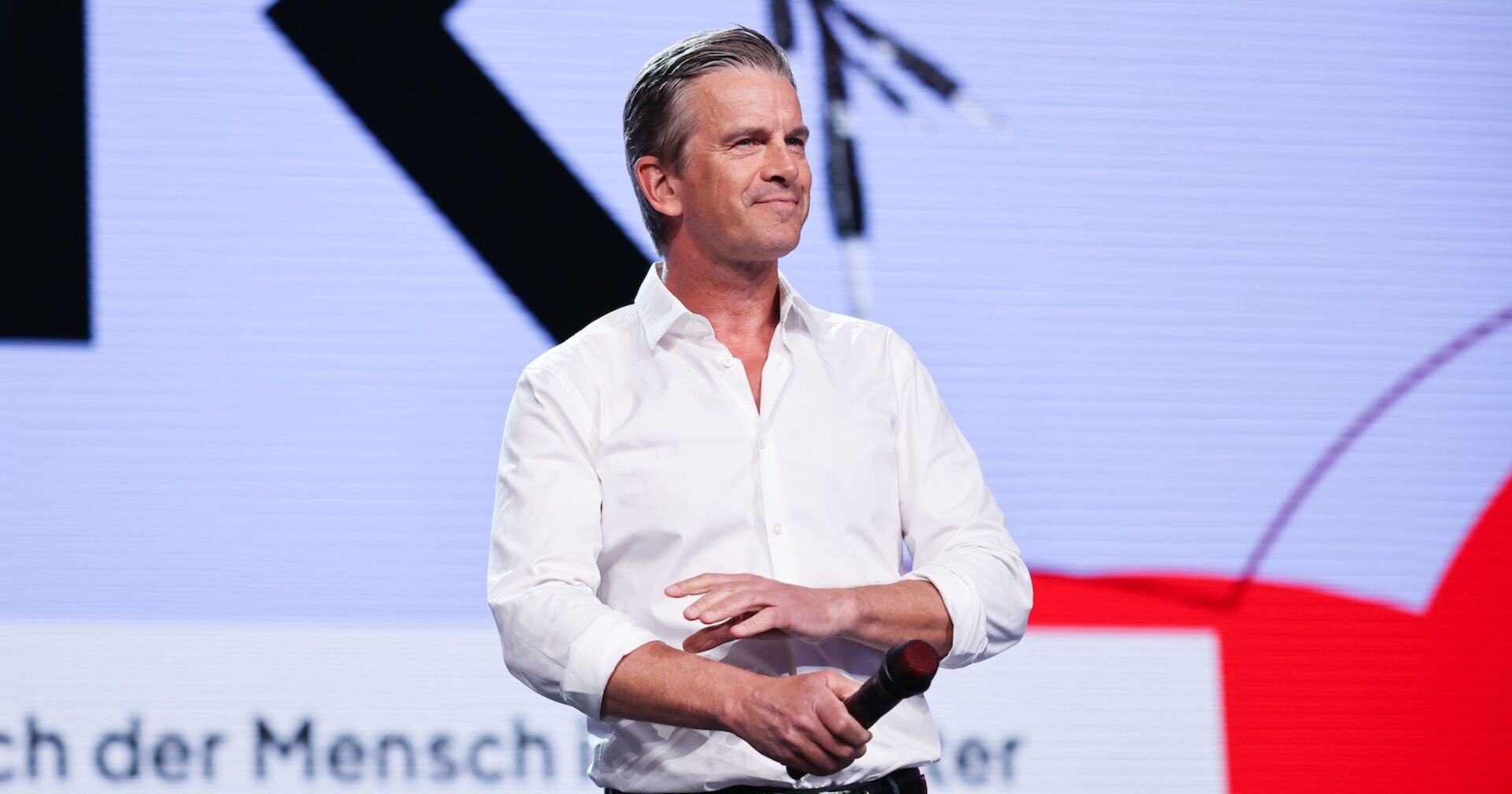 Markus Lanz mit Mikrofon auf der Bühne.