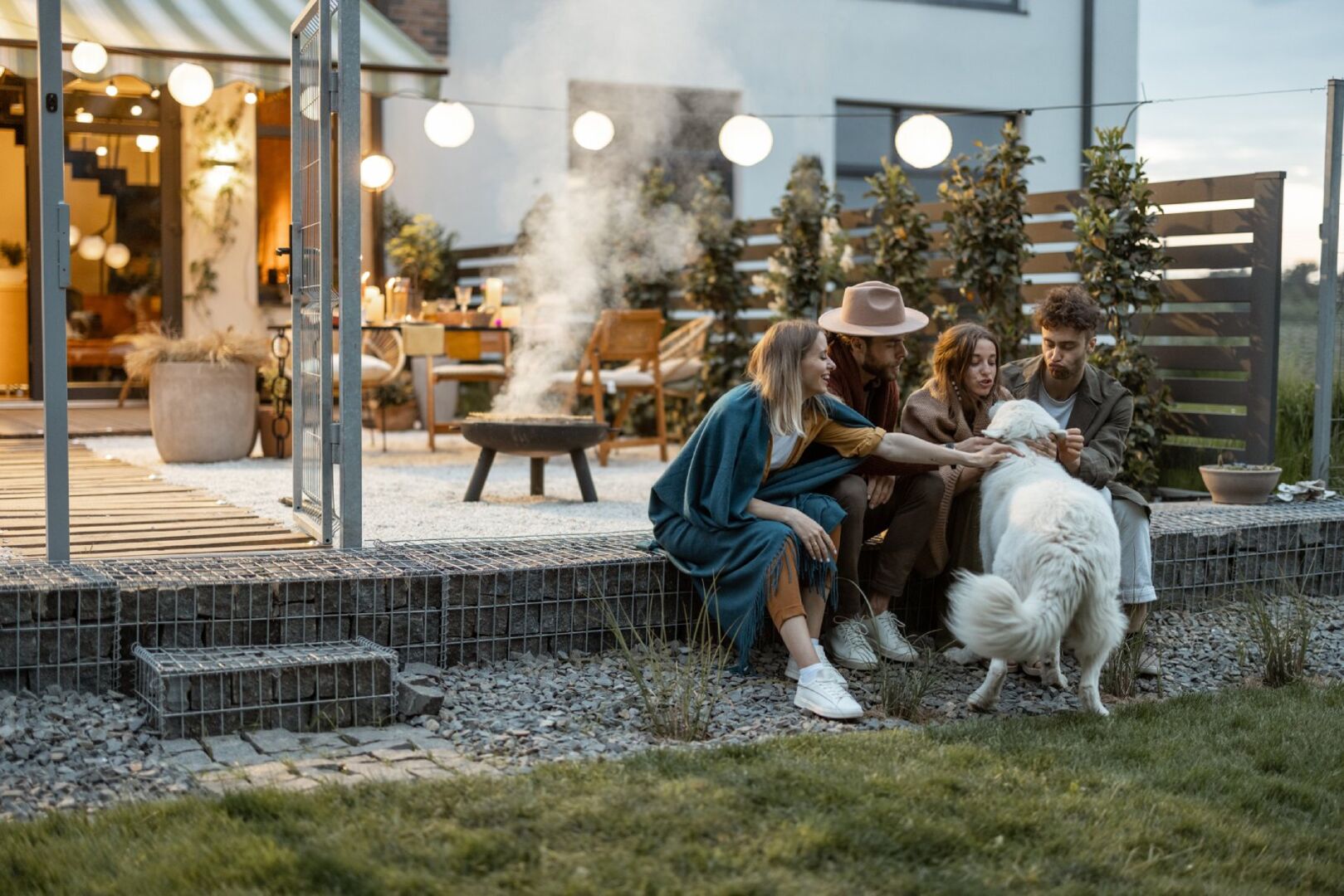 Freunde sitzen zusammen im Garten | Credit: iStock.com/RossHelen