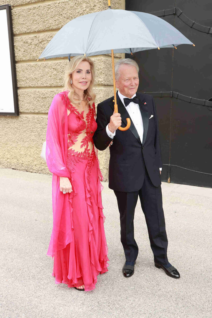 Mit Regenschrirm vor dem Festspielhaus in Salzburg.