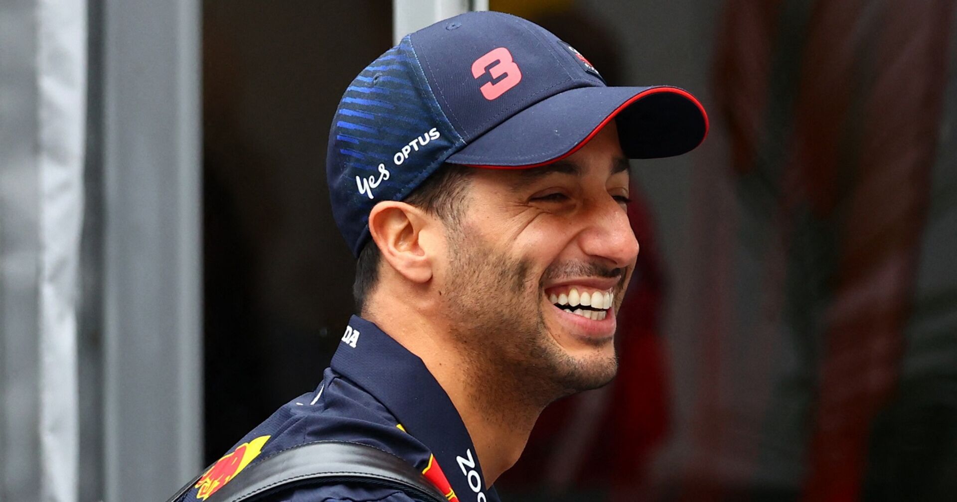Ricciardo mit Kappe in Red Bull Shirt lacht breit.