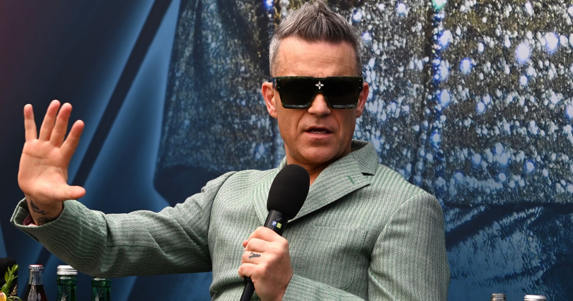 Robbie Williams mit Sonnenbrille bei einem Interview