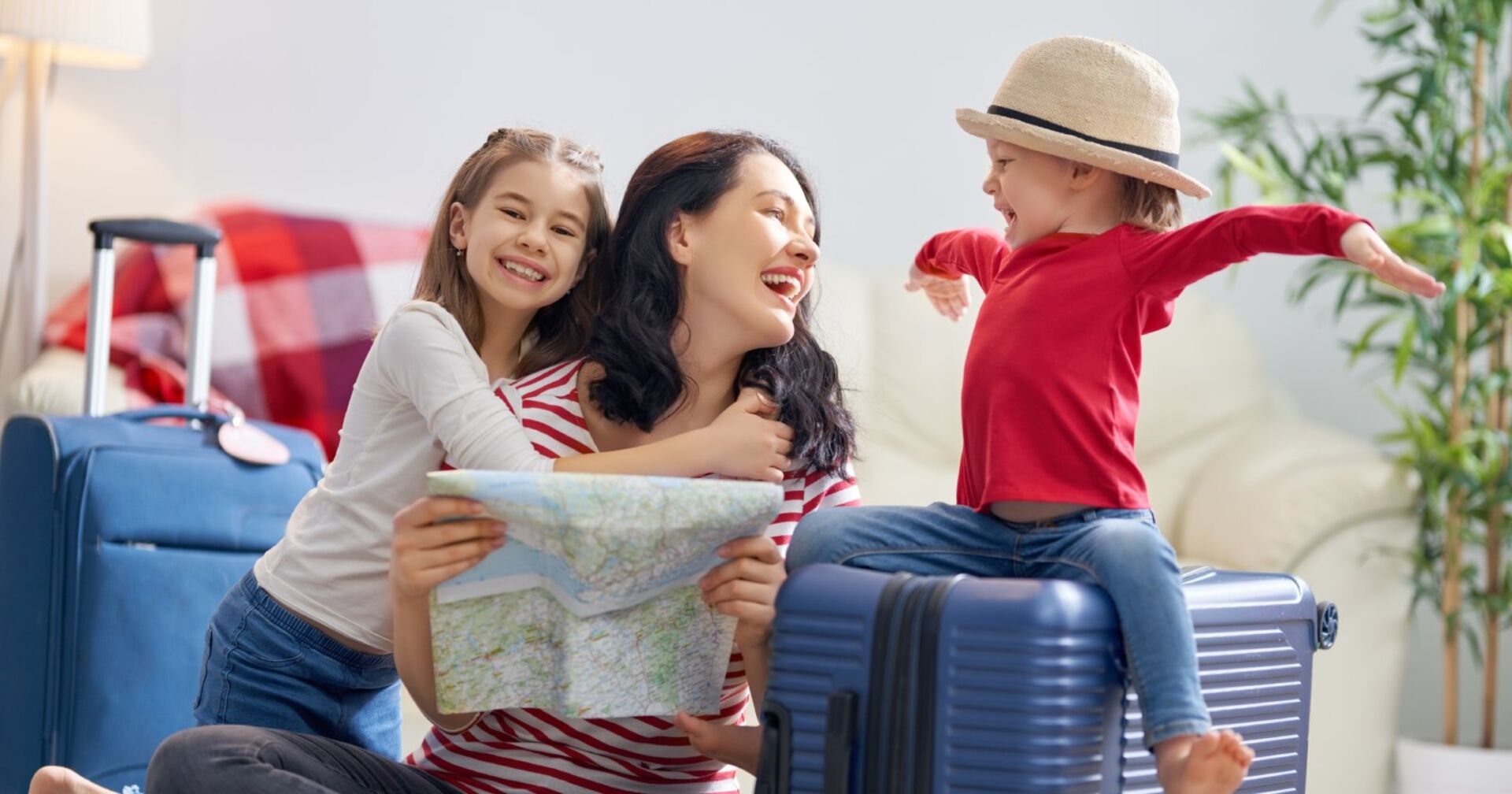 Mutter und zwei Kinder planen den Urlaub | Credit: iStock.com/Choreograph
