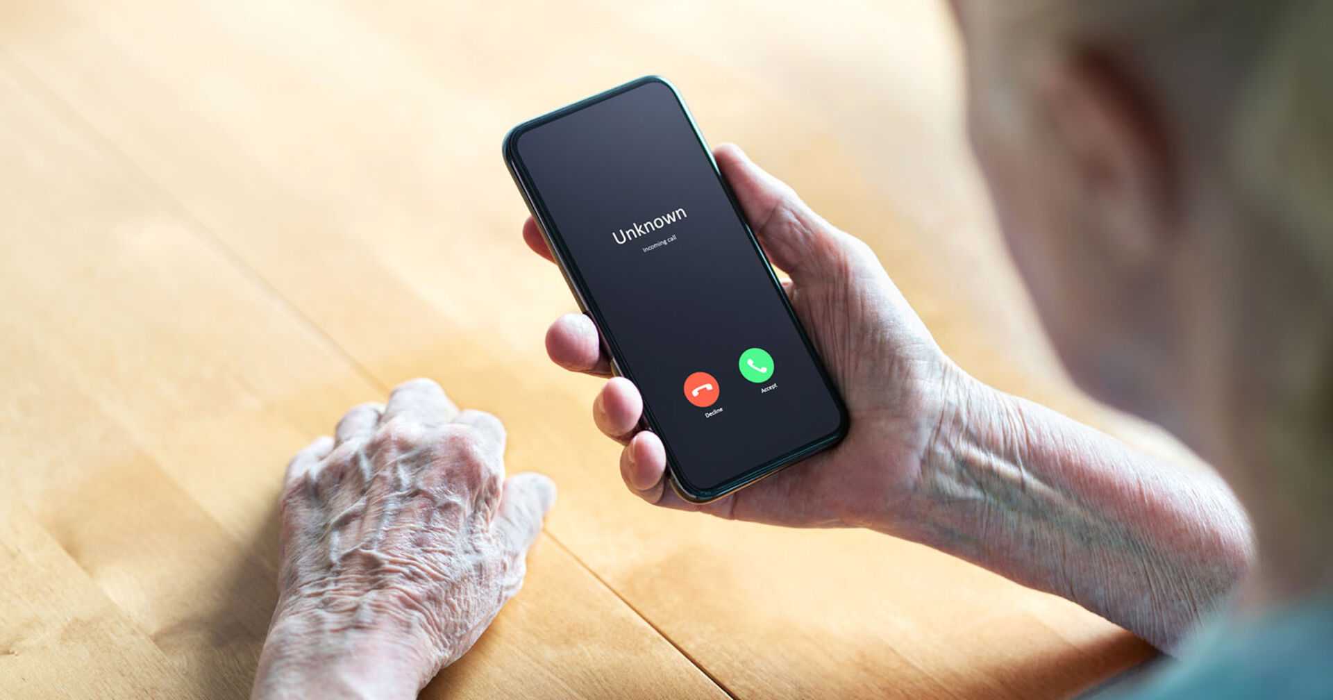 Ältere Frau mit einem Smartphone wir von einem unbekannten Anrufer angerufen.