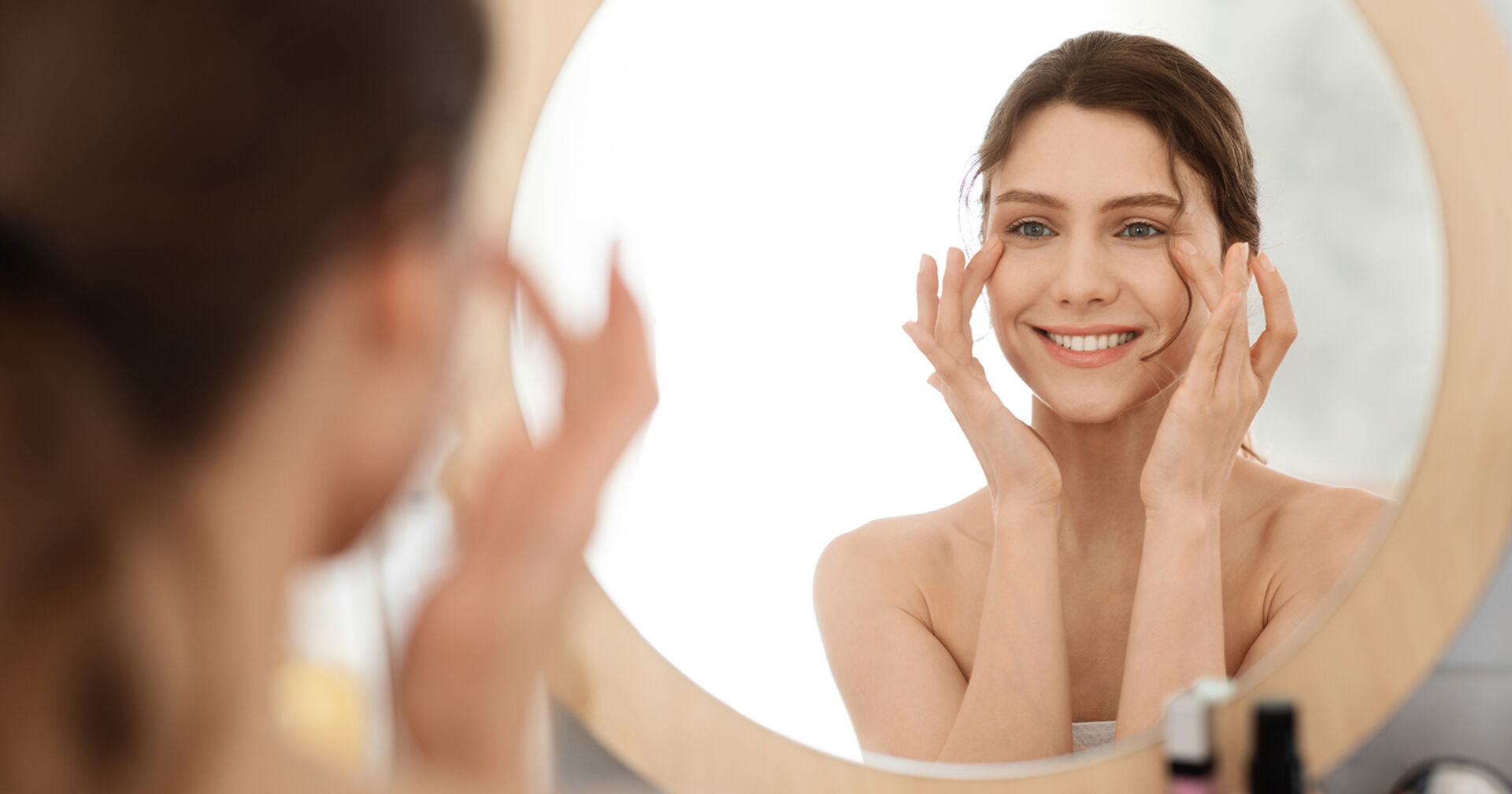 Frau schaut in Spiegel | Credit: iStock.com/Prostock-Studio