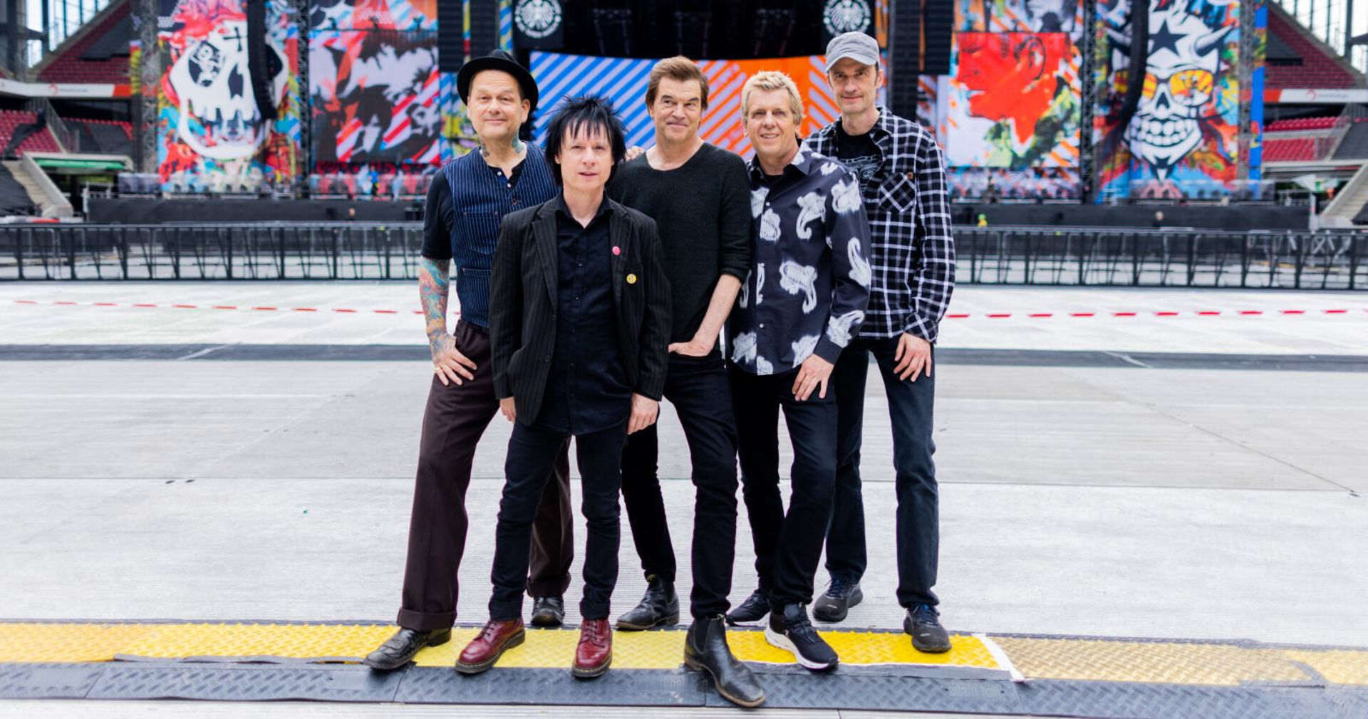 Die Toten Hosen stehen vor einer Bühne.