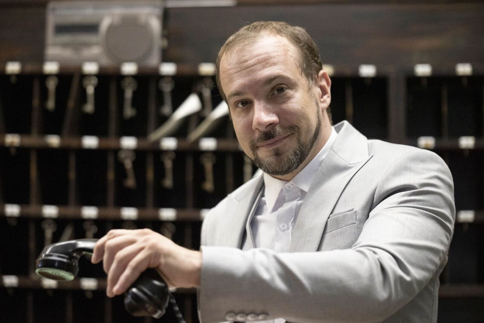 Florian Teichtmeister hebt den Hörer eines alten Telefons ab.