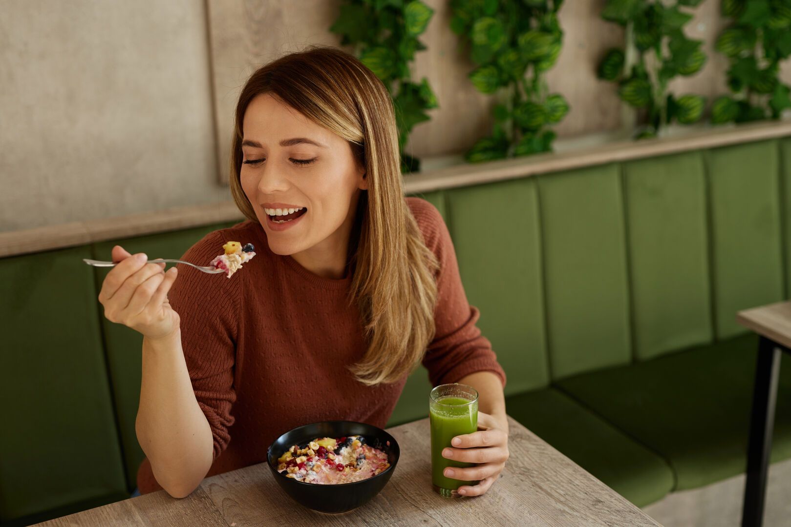 Frau isst Müsli bei Tisch
