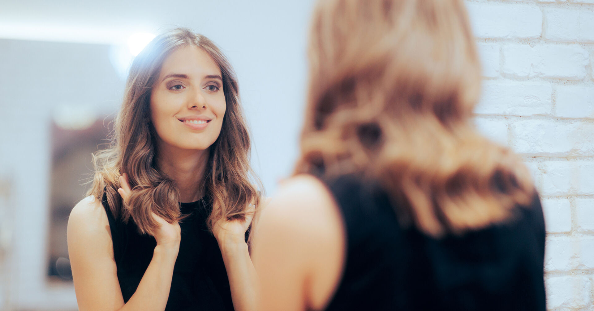 Frau sieht selbstbewusst in den Spiegel | Credit: iStock.com/nicoletaionescu