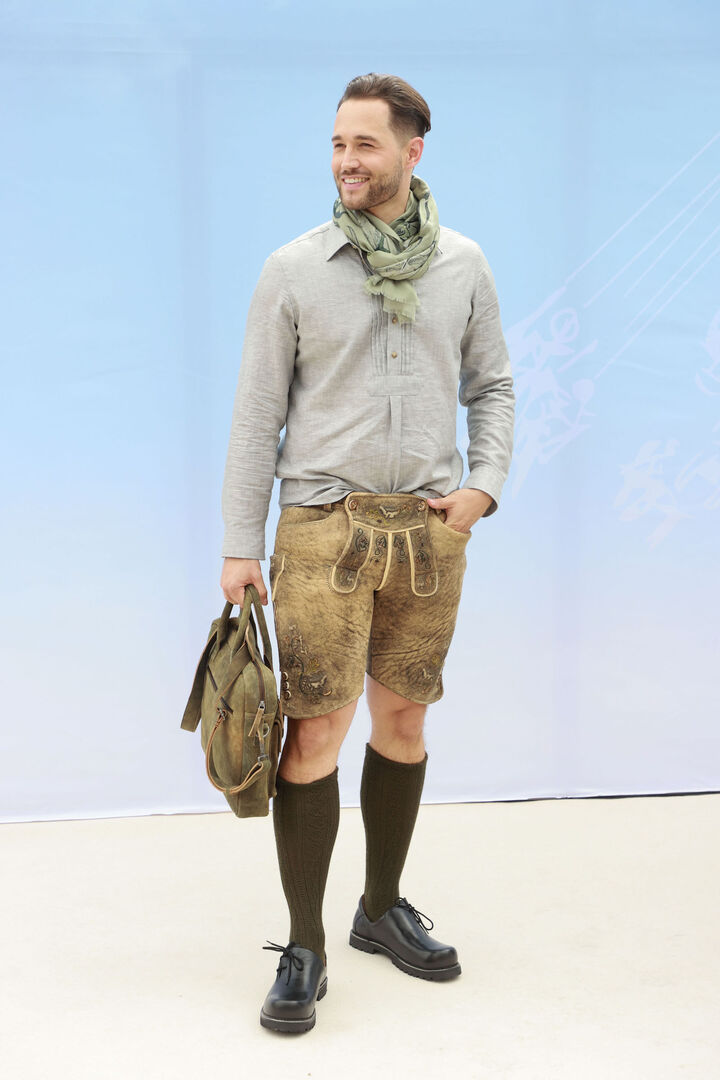 Model präsentiert Lederhose mit Leinenhemd.