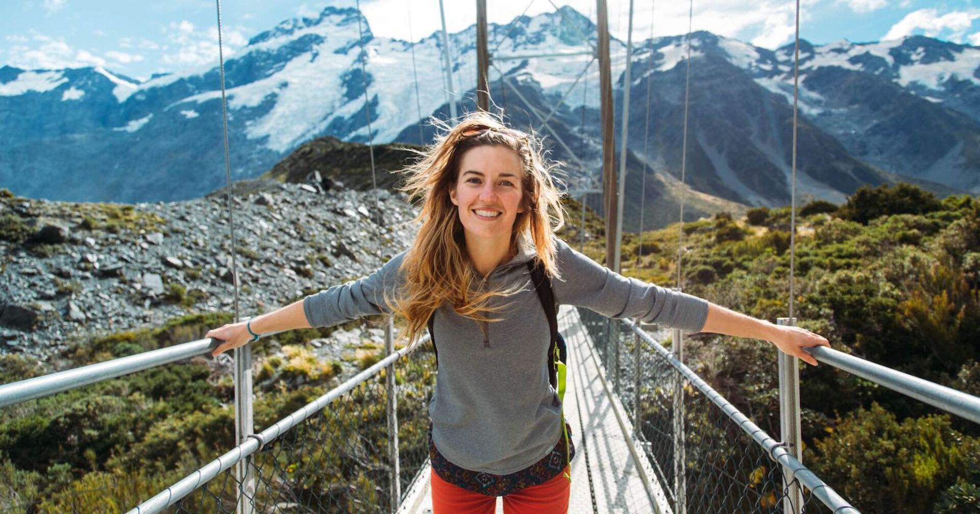 Frau wandert über eine Hängebrücke.