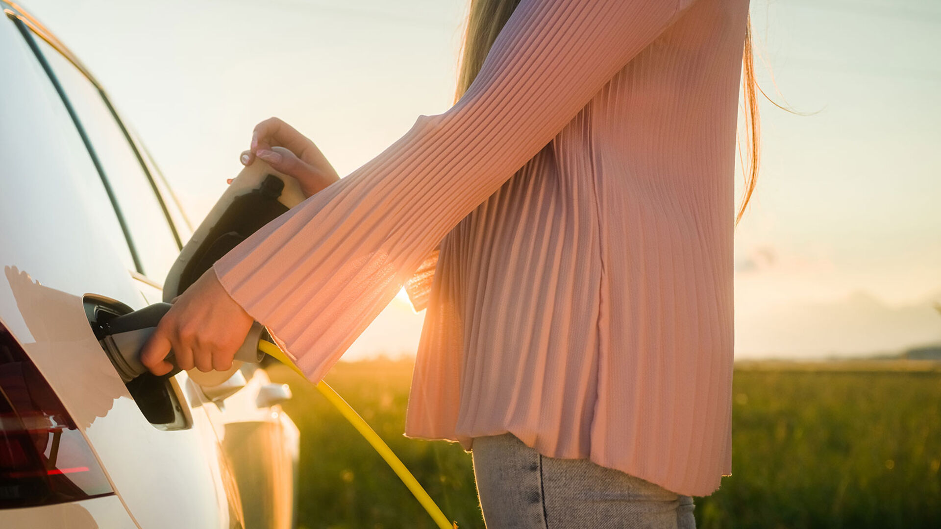 Junge Frau beim Laden ihres E-Autos | Credit: iStock.com/24K-Production